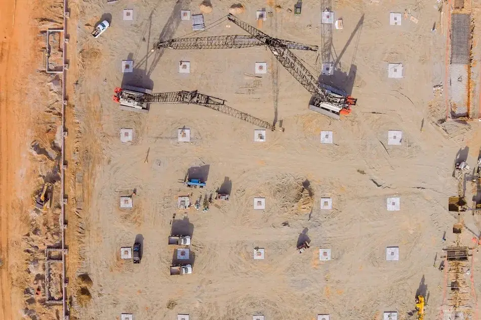 Construction plans, hard hat, level, and tools laid out on a workbench
