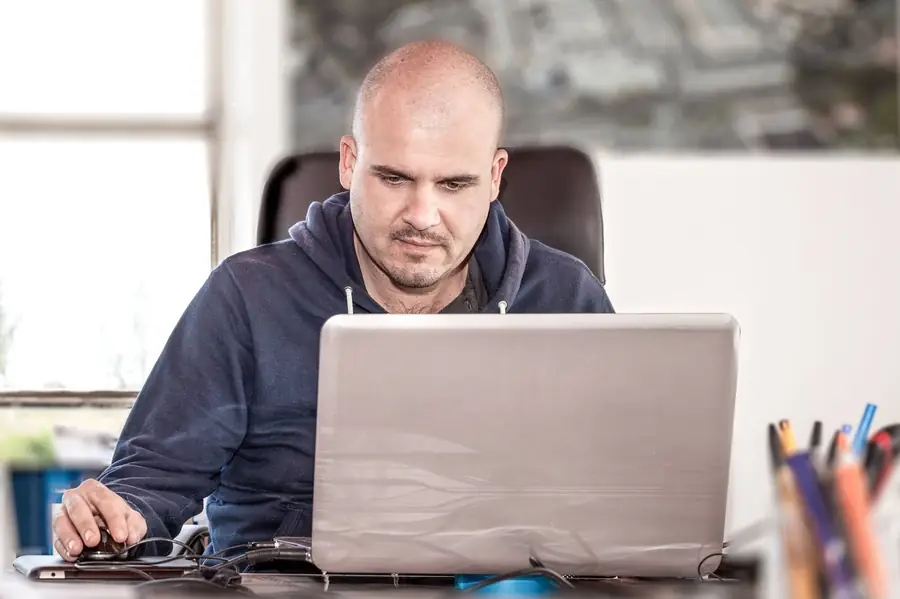 A construction professional working at a desk on a laptop